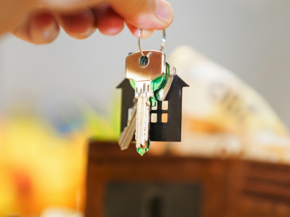Home buyer holding house keys and a wallet while planning closing costs for a Dunedin, Florida purchase