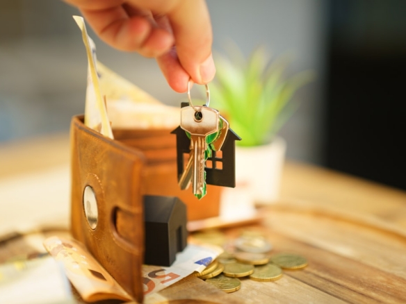 House keys, wallet and household bills representing the monthly cost of owning a home in Dunedin, Florida
